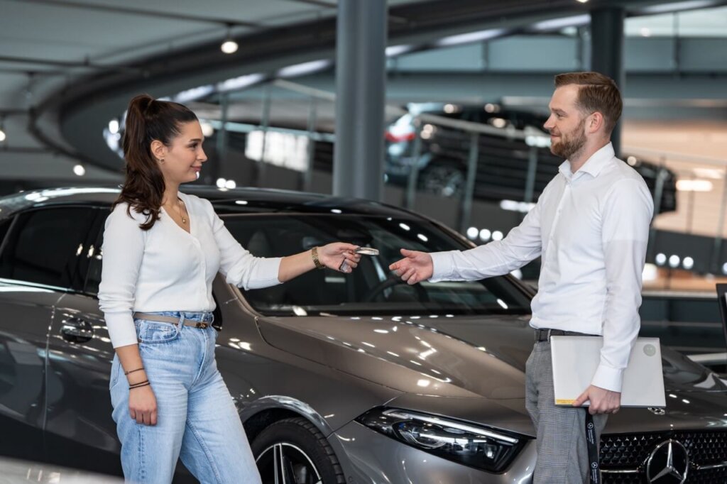 Frau gibt Autohändler Fahrzeugschlüssel zurück