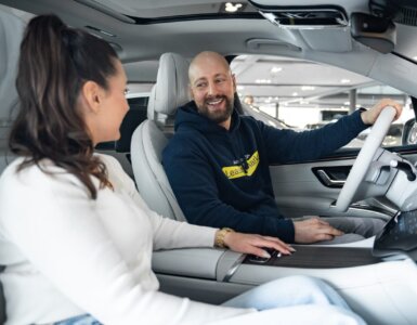 Frau und Mann sitzen lachend im Auto