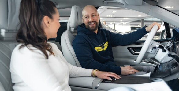 Frau und Mann sitzen lachend im Auto